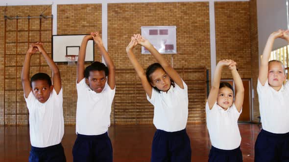School kids exercising in basketball court