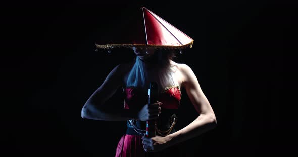 Portrait of a Young Pretty Woman in Traditional Japanese Hat Holding a Katana 