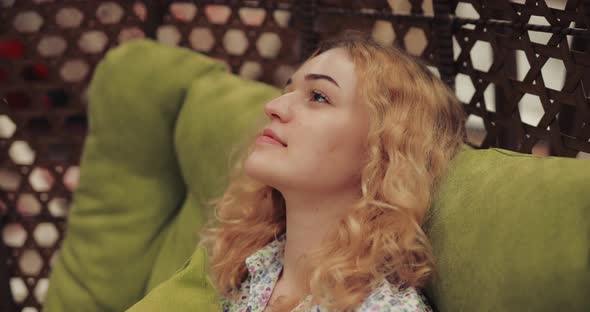 Woman Relaxing Sitting in a Cocoon Chair