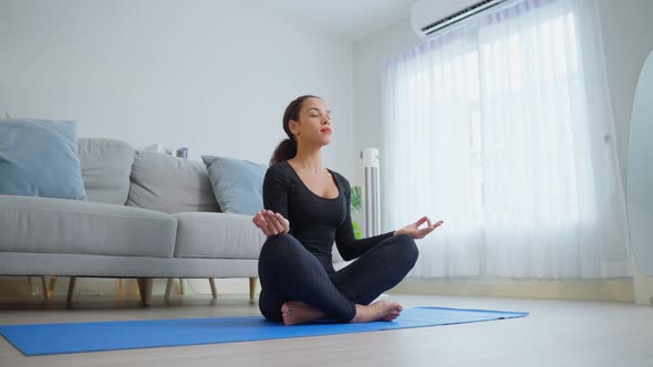 Latino young beautiful active woman doing Yoga Pilates workout exercise in living room at home.