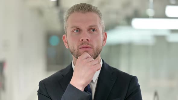 Portrait of Pensive Young Businessman Thinking About Something