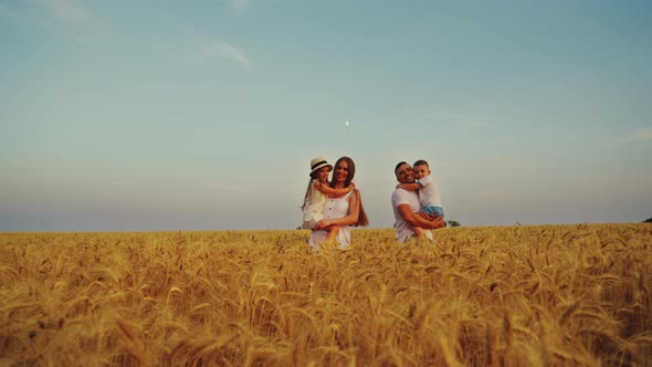 Loving Family Walking in Field in Summer