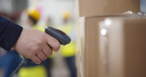 Close Up of Warehouse Worker Scanning Barcode on Cardboard Box