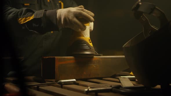 Worker polishing metal with grinder
