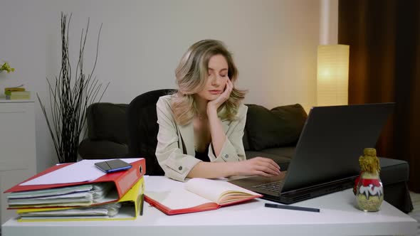 Caucasian business woman falling asleep at desk, sitting at table with laptop.