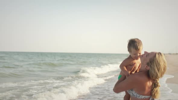 Mom Throws Her Son Up Over the Sea on Summer Vacation Under the Warm Sun