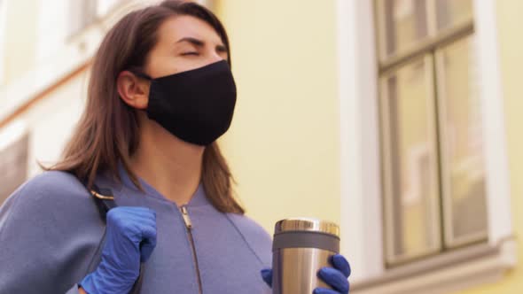 Woman in Reusable Mask with Tumbler in City
