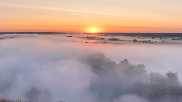 Timelapse Mist Curling Over River and Meadow on Sunrise Background