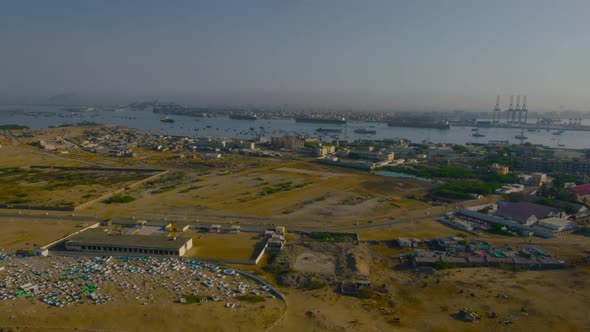 A sea port aerial/drone view with ships, boats, container, cranes and machinery.