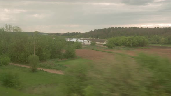 View From Window of Highspeed Train on Landscape of Beautiful Nature Wild Field and Forest on