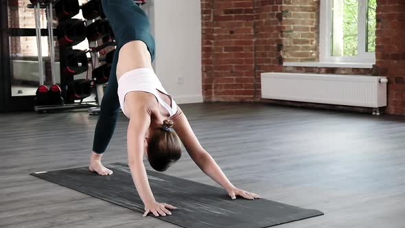 Girl Doing Yoga Exercises Standing in Downward Facing Dog Pose Asana Bakasana