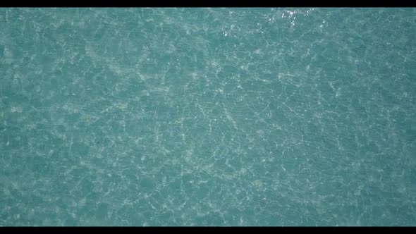 Aerial drone shot scenery of tranquil island beach adventure by turquoise sea and bright sand backgr