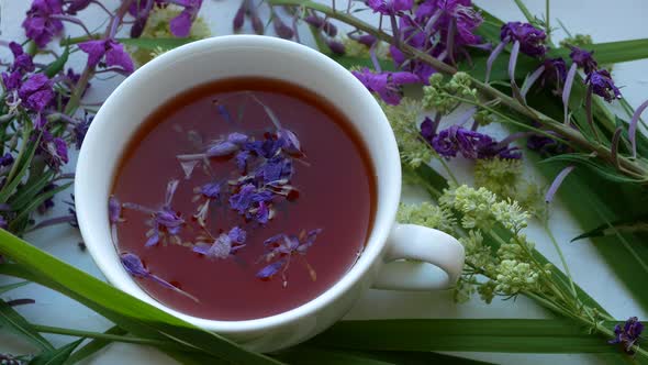 Cup of herbal tea . Tea leaves at the bottom of the cup. Tea time. Blooming sally.