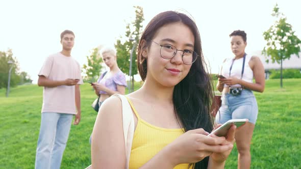 Slow motion young happy asiatic woman outdoor using smartphone