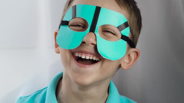 Happy Little Boy Playing a Superhero, Masked Comic. A Child Plays Hide-and-seek. The Boy Laughs