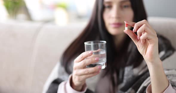 Woman is Holding Pill and Glass of Water