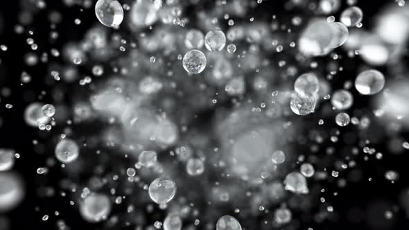 Explosion of Water Droplets Into the Camera in Slow Motion on an Isolated Black Background. alt