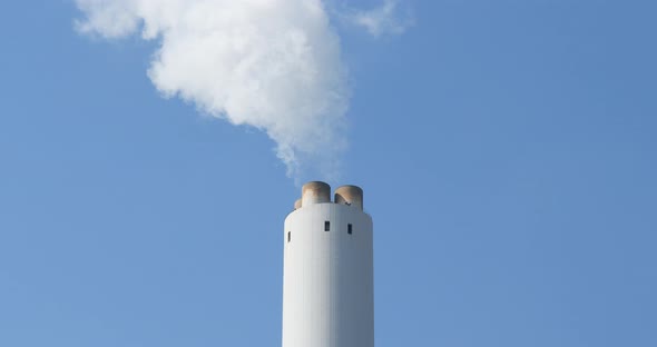 Smoke stack with a nice smoke over blue sky