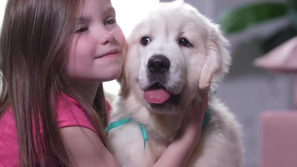 Portrait of Sweet Little Girl Cuddling with Puppy