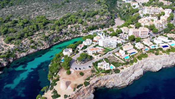 Town of Torrent de Cala Pi with watch tower near the lookout on Mallorca Spain, Aerial orbit left sh