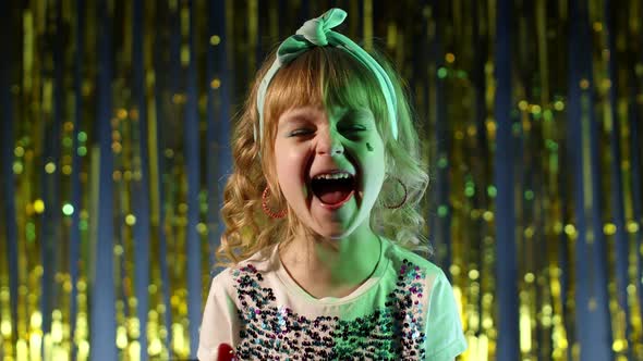 Child Kid in Neon Lighting Posing at Disco Party Cyberpunk Studio Girl Making Faces Fooling Around