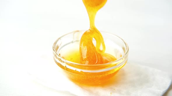 Sugar Paste or Wax Honey for Hair Removing Flows Down From Wooden Waxing Spatula Sticks Depilation