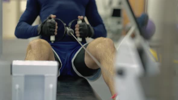 Man Performs an Exercise to Restore the Muscles of the Back and Hands