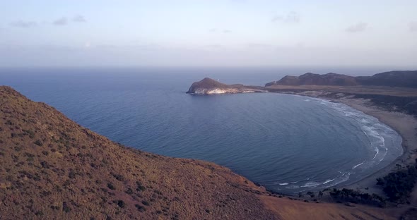 Panning wide drone shot of Genoveses beach in Nijar Bay, Almeria. Touristic Spanish place in summer.