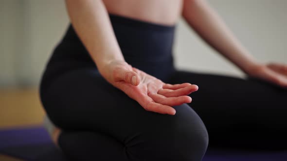 Close up: athletic woman doing yoga for health. The girl is in the lotus position