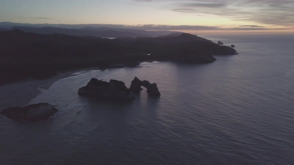 Dark New Zealand coastline during sunset