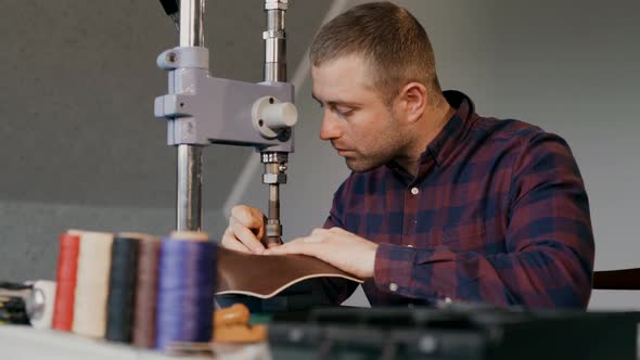 The Process of Manufacturing a Leather Wallet Handmade. Man Makes Stamping on the Leather. Own