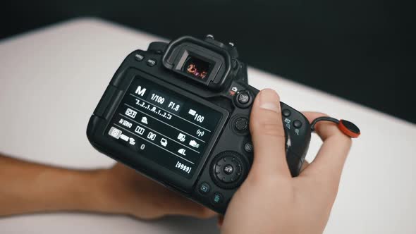 Photographer adjusting the settings on a professional camera, using the different configurations on