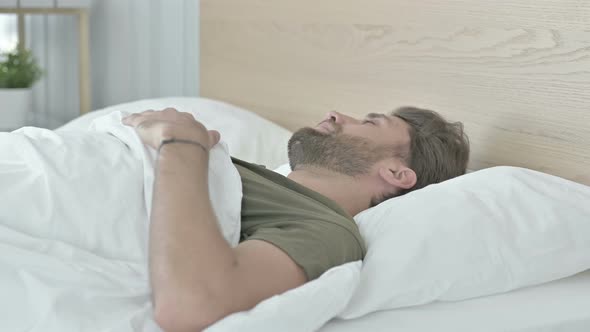 Depressed Young Man Having Rough Nap in Bed