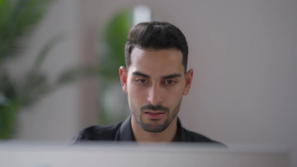 Closeup Portrait of Young Nervous Middle Eastern Man Slapping Computer Monitor in Home Office