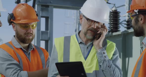 Foreman Speaking with Colleagues on Power Station