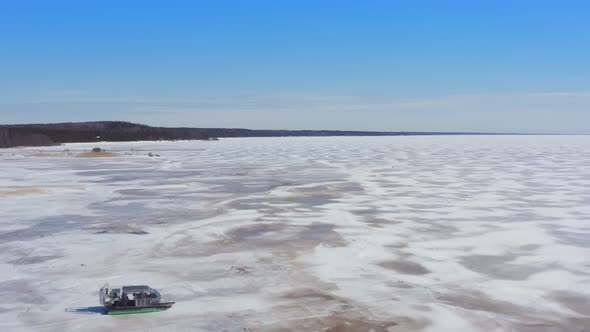 Aerial View of Hovercraft Riding on Snowcovered Ice of Lake in Winter
