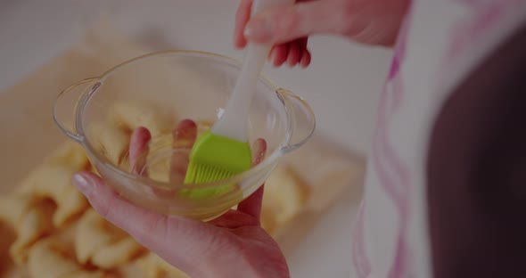 Woman Making Tasty Croissants on Table in Kitchen