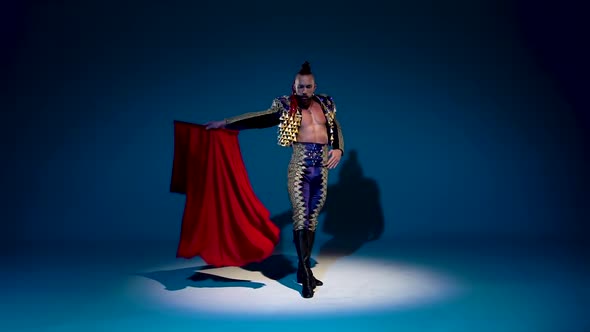 Torero in Blue and Gold Suit or Typical Spanish Bullfighter Isolated Spotlight on a Blue Background