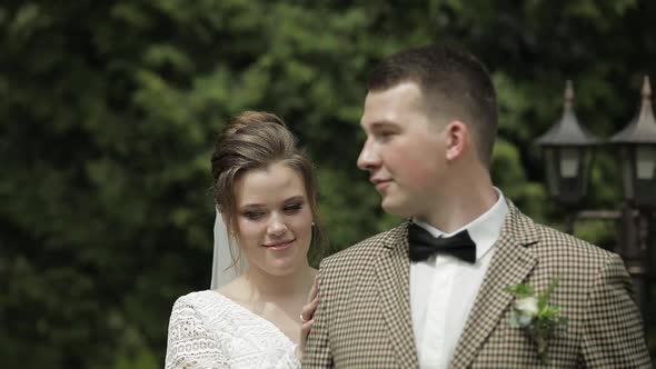 Newlyweds. Caucasian Groom with Bride Walking in Park. Wedding Couple. Man and Woman in Love