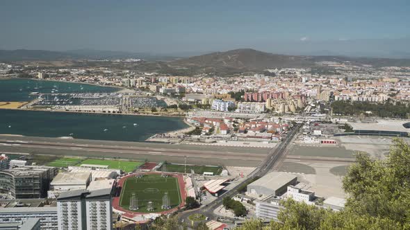 Airport and runway in Gibraltar bay harbor and city port, panning shot.