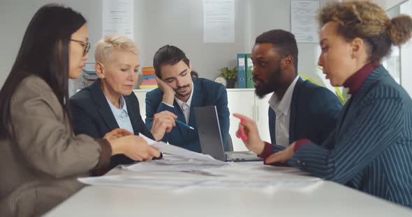 Bored Businessman Sleeping During Business Meeting with Colleagues