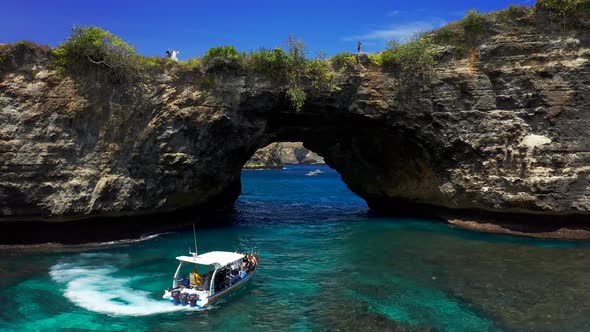 Aerial View of Tourist Speedboat at Azure Sea in Broken Beach, Nusa Penida, Bali, Indonesia. Aerial 