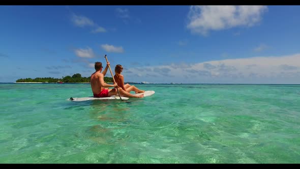 Guy and girl tanning on exotic island beach holiday by blue ocean and white sandy background of the 