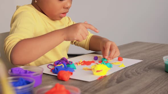 Little Girl with Modeling Clay Playing at Home