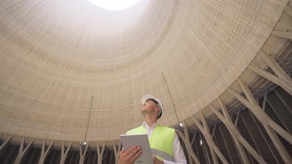 Young engineer works at nuclear power plant.