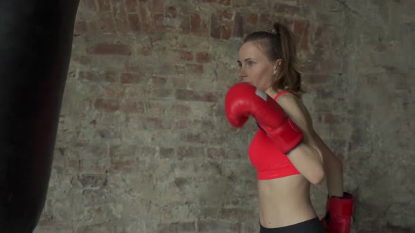 Boxer Young Female Beats Pear in a Modern Gym