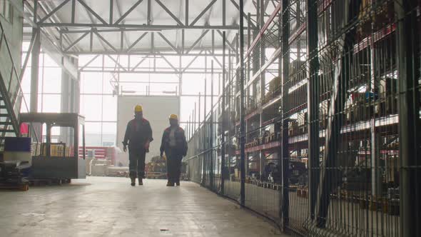 Factory Workers Walking in Warehouse and Talking