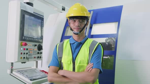 Portrait of male worker operating on the high technology machine in industrial plant with confident