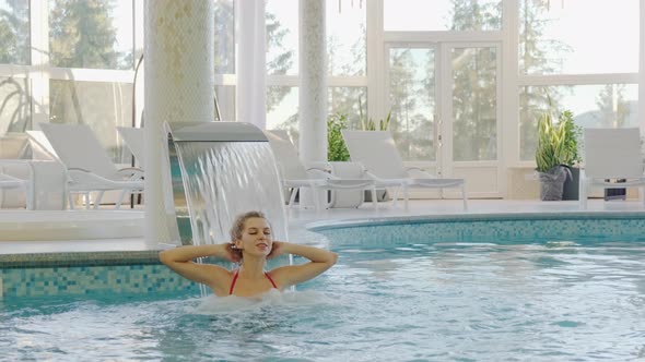 Close Up Young Woman Relaxing Hydrotherapy in Pool at Spa Hotel