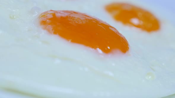 Chicken egg yolks fried and served slow tilt 4K 2160p 30fps UltraHD video - Tasty hen eggs fried fre